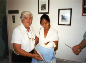 Caridad founder with a woman holding her baby